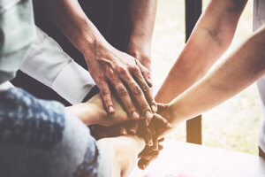 a group of people hold hands as part of their LGBT support groups